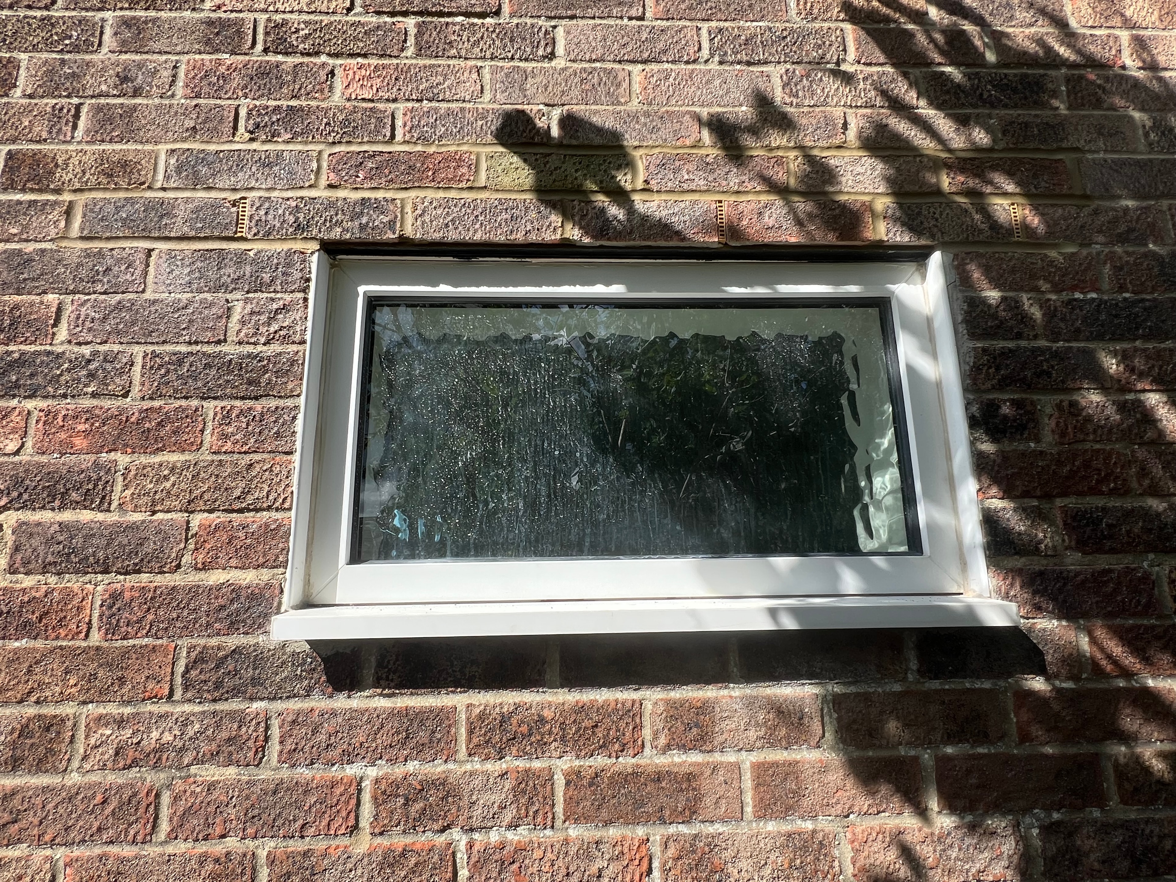 Completed cavity tray installation with window in brick wall